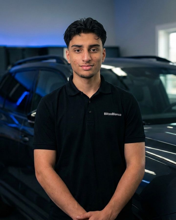 Arwin Kohli im schwarzen BlitzoBlanco-Poloshirt vor einem dunklen SUV